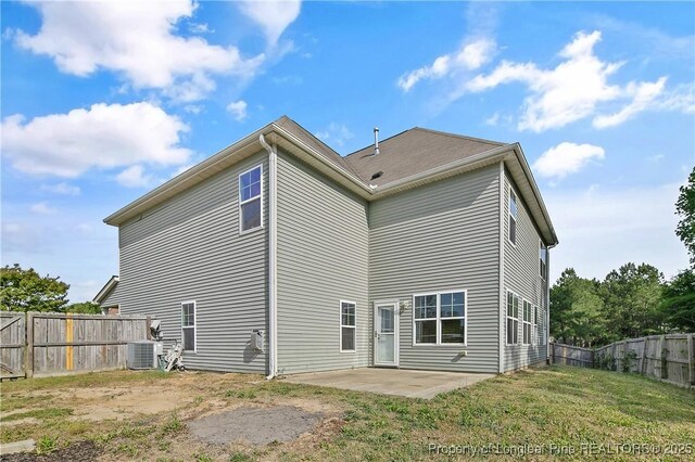 rear view of house with central air condition unit, a patio area, a lawn, and fence