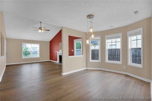 unfurnished living room with wood finished floors, ceiling fan, baseboards, a fireplace with flush hearth, and lofted ceiling