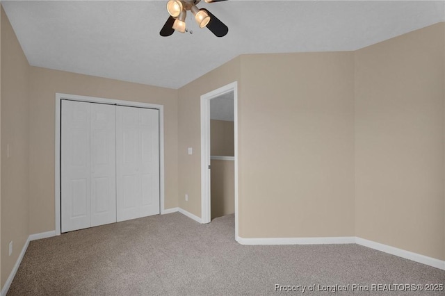 unfurnished bedroom with carpet flooring, a closet, baseboards, and a ceiling fan