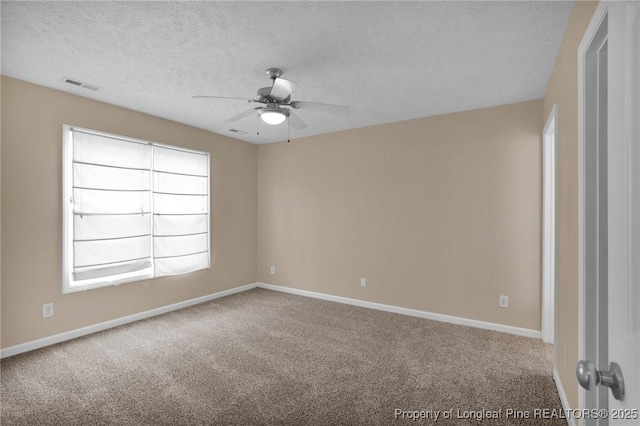 carpeted empty room with a ceiling fan, baseboards, and a textured ceiling
