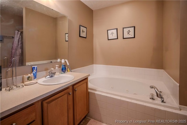full bath with a textured ceiling, a tub with jets, and vanity