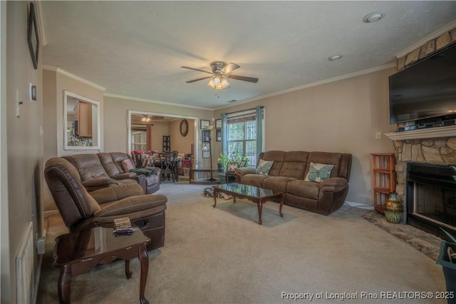 living room with carpet floors, crown molding, a fireplace, baseboards, and ceiling fan