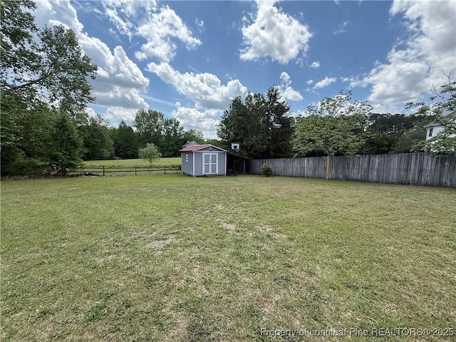view of yard featuring a storage shed, an outbuilding, and a fenced backyard