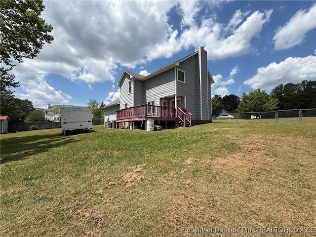 back of house with a lawn, fence, a wooden deck, and a chimney
