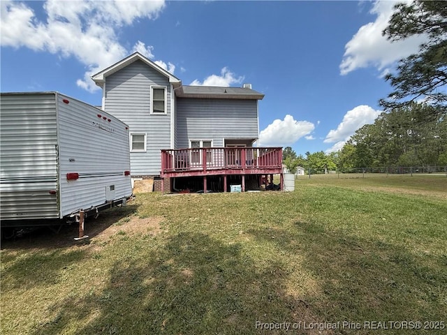 back of house featuring a lawn and a deck