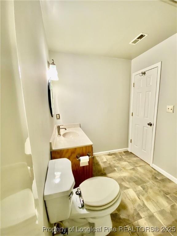 bathroom featuring visible vents, baseboards, toilet, and vanity
