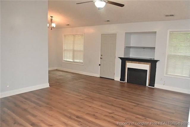279 Hunters Creek Dr, Raeford, NC 28376 - unfurnished living room featuring ceiling fan, a fireplace, dark wood finished floors, a chandelier, and baseboards