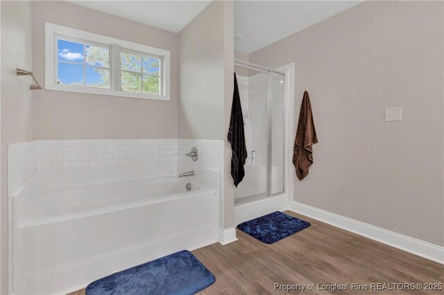 5145 Maxwell Rd, Stedman, NC 28391 - full bathroom with wood finished floors, a stall shower, a garden tub, and baseboards