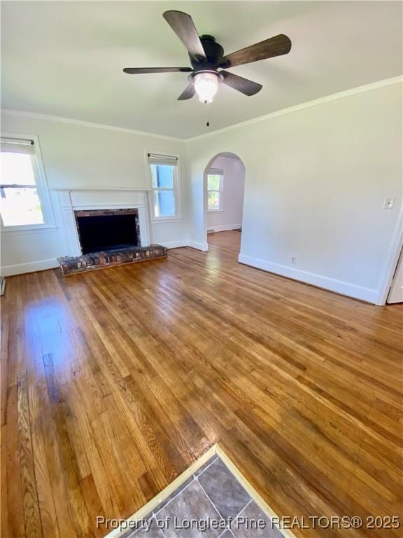 320 W 20th St, Lumberton, NC 28358 - unfurnished living room featuring arched walkways, ceiling fan, plenty of natural light, wood finished floors, and crown molding