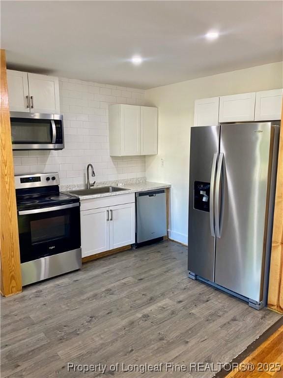320 W 20th St, Lumberton, NC 28358 - kitchen with stainless steel appliances, white cabinets, and wood finished floors