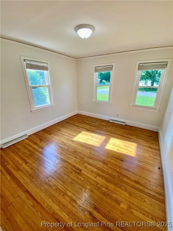 320 W 20th St, Lumberton, NC 28358 - unfurnished room featuring a baseboard radiator, ornamental molding, wood finished floors, and plenty of natural light