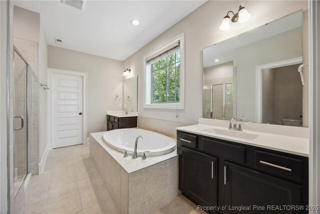 405 Gilpin Way, Cary, NC 27519 - full bathroom featuring a shower stall, two vanities, a garden tub, and tile patterned flooring