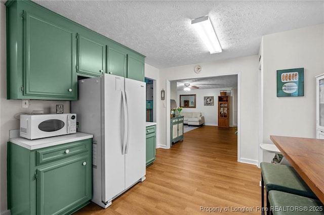 1963 Seabrook School Rd, Fayetteville, NC 28312 - kitchen with white appliances, green cabinetry, light countertops, light wood-style floors, and a textured ceiling