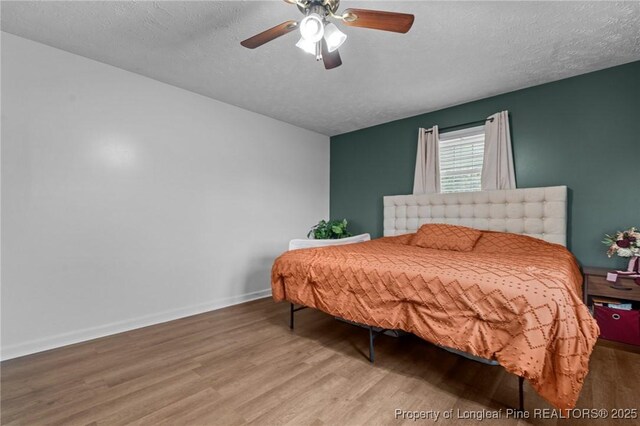 1963 Seabrook School Rd, Fayetteville, NC 28312 - bedroom with wood finished floors, a textured ceiling, baseboards, and a ceiling fan