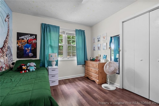 1963 Seabrook School Rd, Fayetteville, NC 28312 - bedroom featuring dark wood-style floors, baseboards, a closet, and a textured ceiling