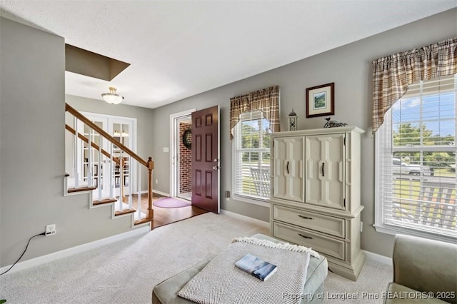 entrance foyer with carpet floors, baseboards, and plenty of natural light