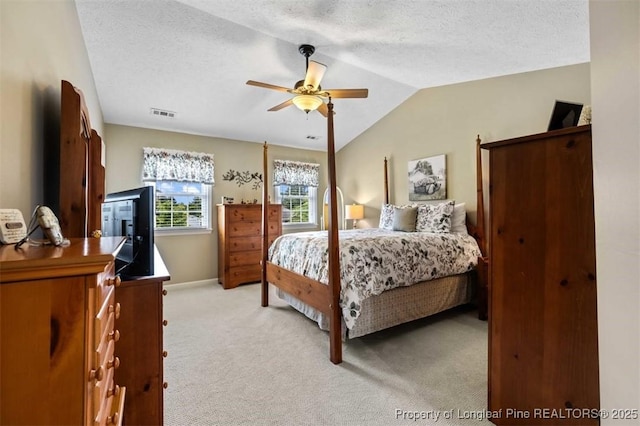 bedroom featuring light colored carpet, lofted ceiling, a ceiling fan, a textured ceiling, and baseboards