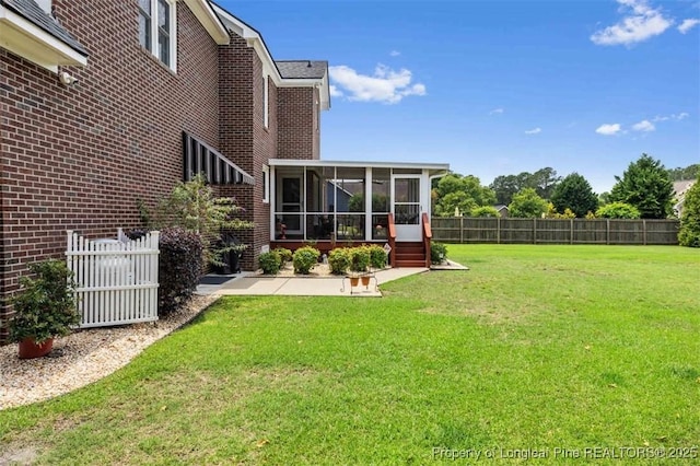view of yard featuring a sunroom and a patio
