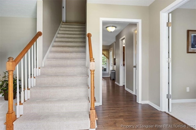 stairway featuring wood finished floors and baseboards