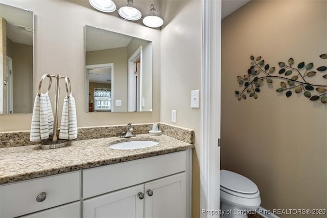 bathroom featuring vanity and toilet