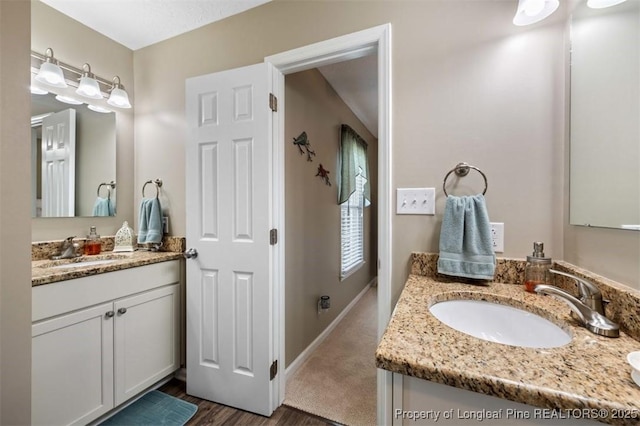 bathroom featuring vanity, baseboards, and wood finished floors