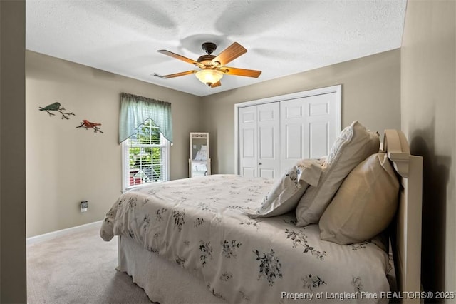 bedroom with light carpet, baseboards, a closet, ceiling fan, and a textured ceiling