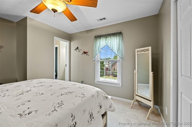 bedroom featuring light colored carpet, baseboards, and a ceiling fan