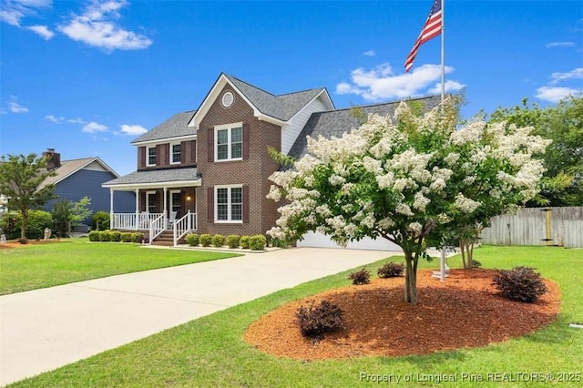 view of front of home featuring driveway, covered porch, and brick siding