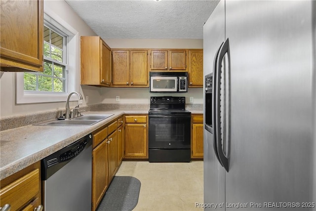 303 Whipple Tree Ln, Fayetteville, NC 28314 - kitchen featuring appliances with stainless steel finishes, light countertops, brown cabinetry, a textured ceiling, and light flooring