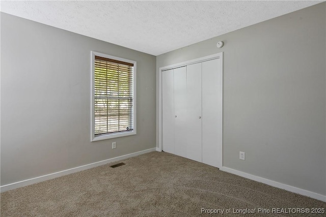 303 Whipple Tree Ln, Fayetteville, NC 28314 - unfurnished bedroom with carpet flooring, a textured ceiling, and a closet