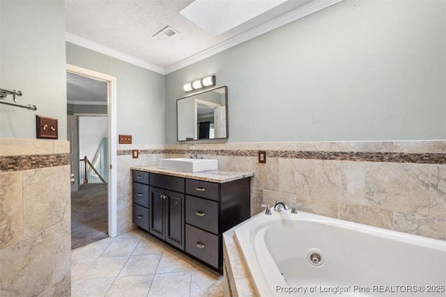 7616 Spurge Dr, Fayetteville, NC 28311 - full bath with tile walls, vanity, a tub with jets, crown molding, and wainscoting