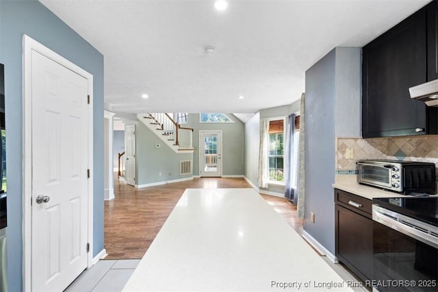 7616 Spurge Dr, Fayetteville, NC 28311 - kitchen featuring stainless steel electric stove, light countertops, tasteful backsplash, open floor plan, and recessed lighting