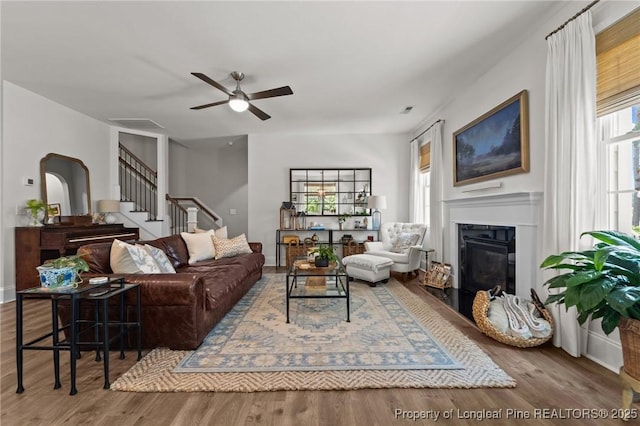 500 Legacy Lakes Way, Aberdeen, NC 28315 - living room with a ceiling fan, wood finished floors, stairs, and a glass covered fireplace