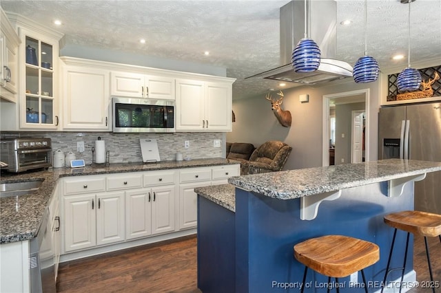 kitchen featuring appliances with stainless steel finishes, tasteful backsplash, white cabinetry, glass insert cabinets, and a textured ceiling