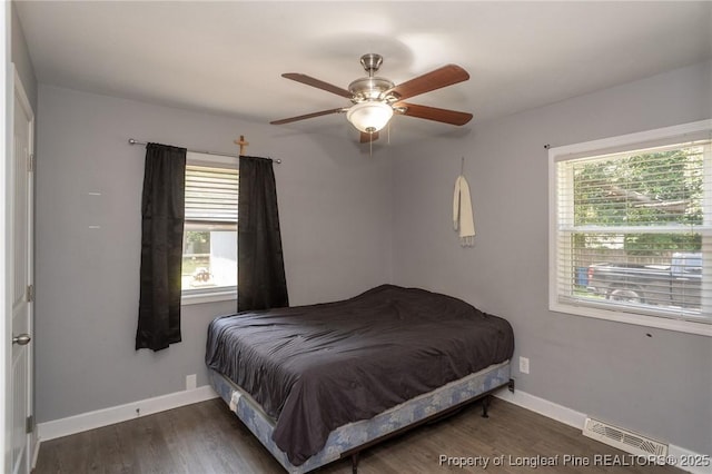 bedroom with multiple windows, wood finished floors, and ceiling fan
