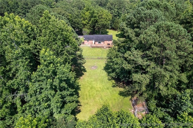 view of subject property with a heavily wooded area