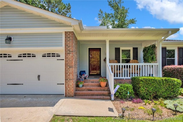 4327 Falls Dr, Hope Mills, NC 28348 - view of exterior entry featuring an attached garage, a porch, and concrete driveway