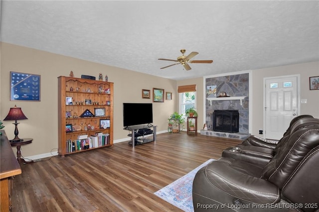 4327 Falls Dr, Hope Mills, NC 28348 - living area featuring a textured ceiling, wood finished floors, a ceiling fan, and a large fireplace