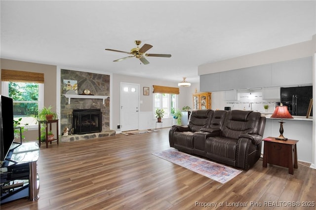 4327 Falls Dr, Hope Mills, NC 28348 - living area featuring ceiling fan, wood finished floors, and a stone fireplace