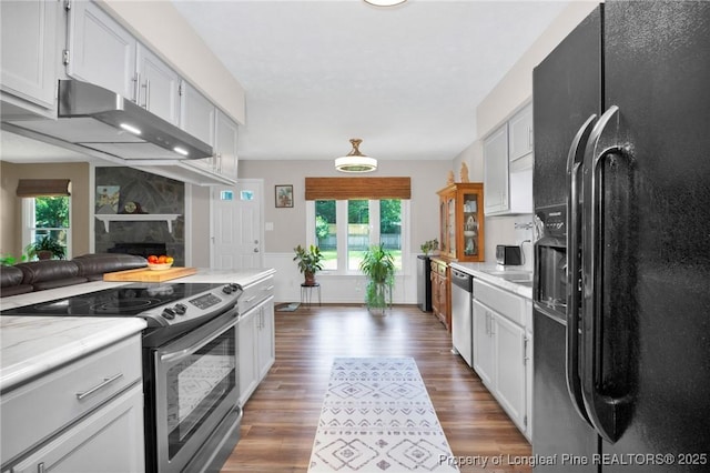 4327 Falls Dr, Hope Mills, NC 28348 - kitchen with stainless steel appliances, under cabinet range hood, healthy amount of natural light, and a large fireplace
