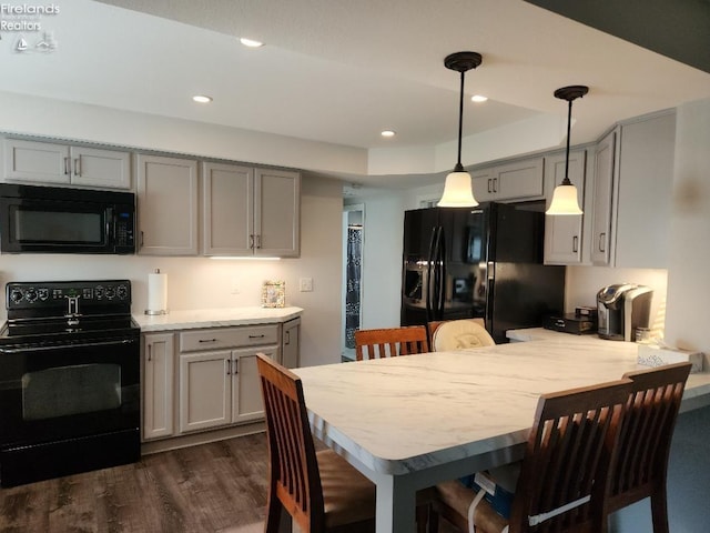 kitchen with decorative light fixtures, dark hardwood / wood-style floors, kitchen peninsula, gray cabinetry, and black appliances