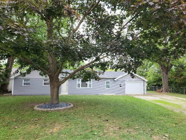 view of front of home with a front yard and a garage