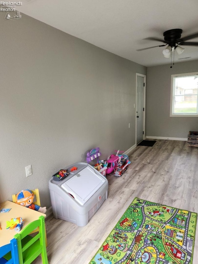 playroom with ceiling fan and light hardwood / wood-style flooring