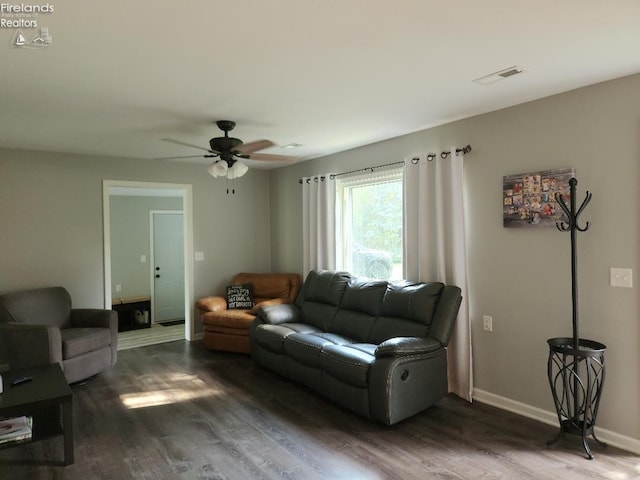 living room with ceiling fan and dark wood-type flooring