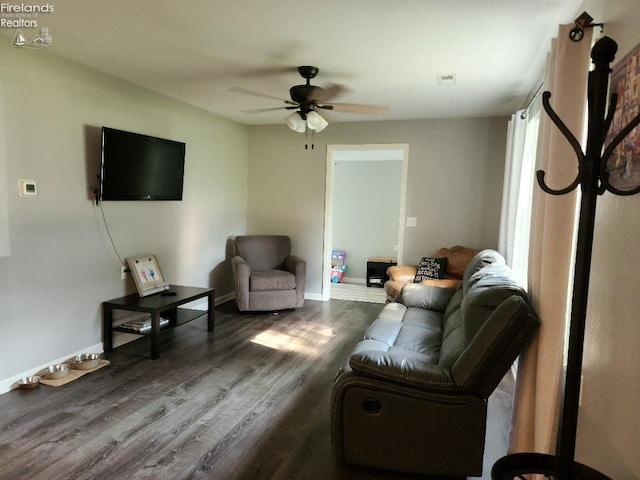 living room with ceiling fan and dark wood-type flooring