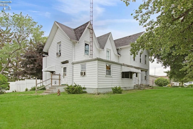 rear view of house featuring a yard and cooling unit