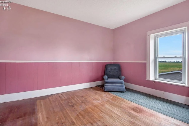 unfurnished room featuring wood walls and light wood-type flooring