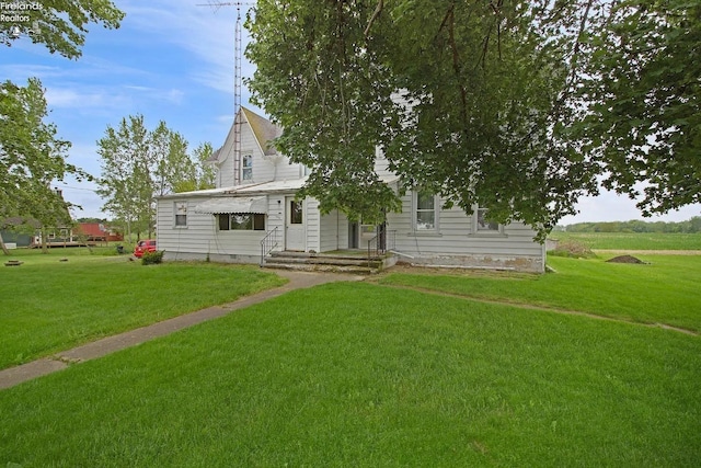 rear view of property featuring a lawn