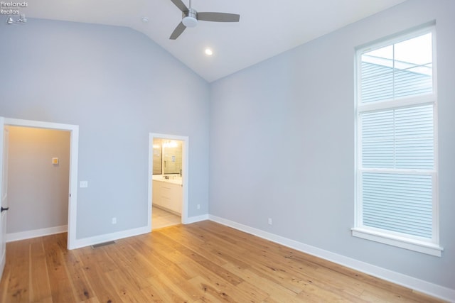 unfurnished bedroom with light wood finished floors, visible vents, baseboards, and high vaulted ceiling