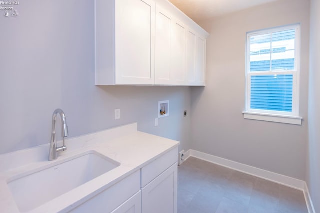 laundry room featuring hookup for a washing machine, a sink, baseboards, cabinet space, and electric dryer hookup